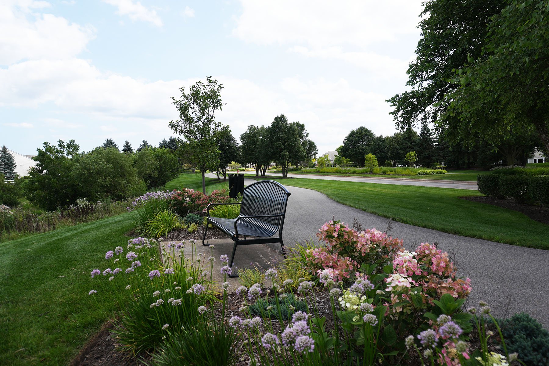 bench surrounded by pink & purple flowers | HOA Landscaping Yellowstone Landscape