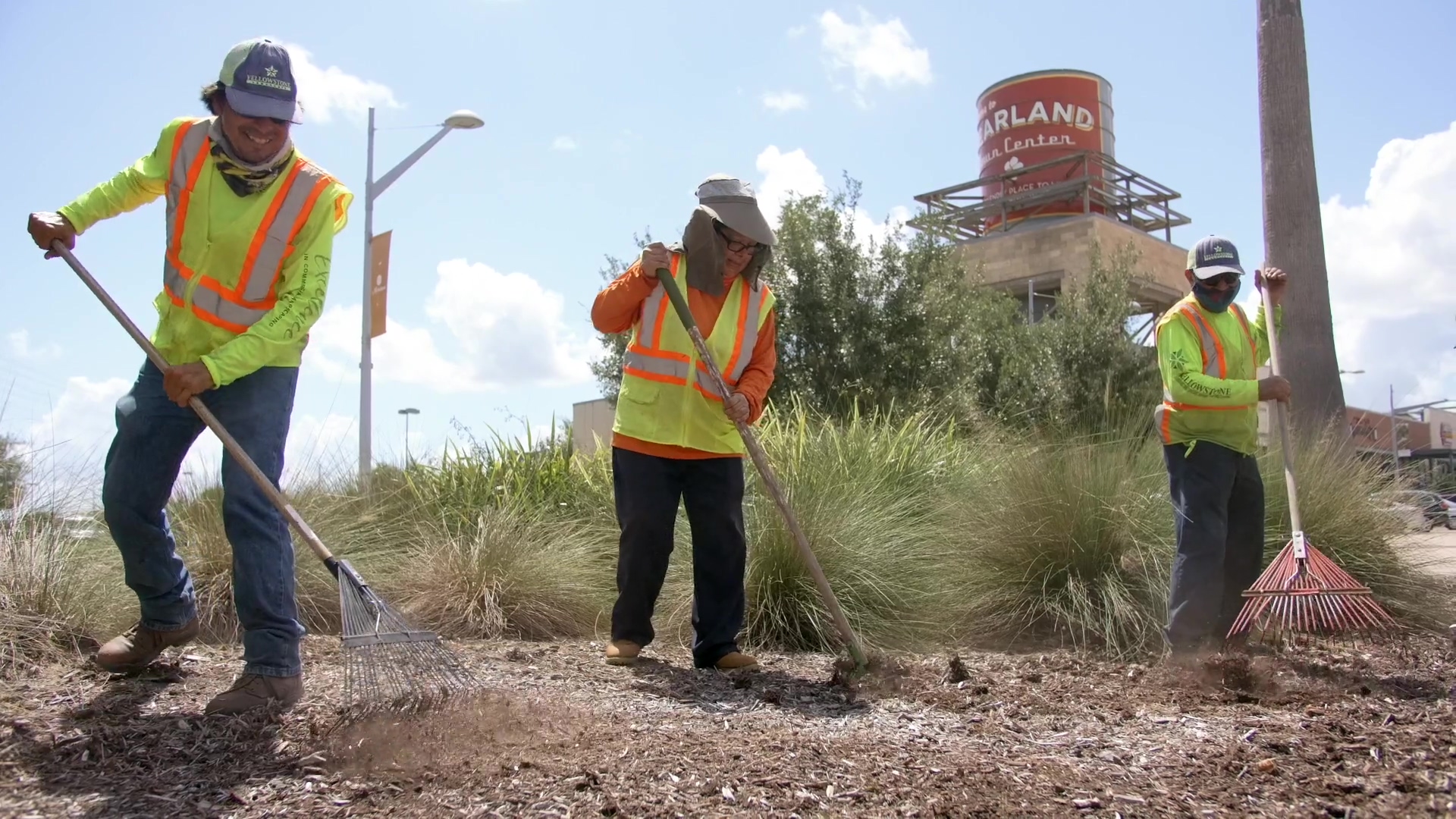 Commercial landscape maintenance crew maintaining a garden bed